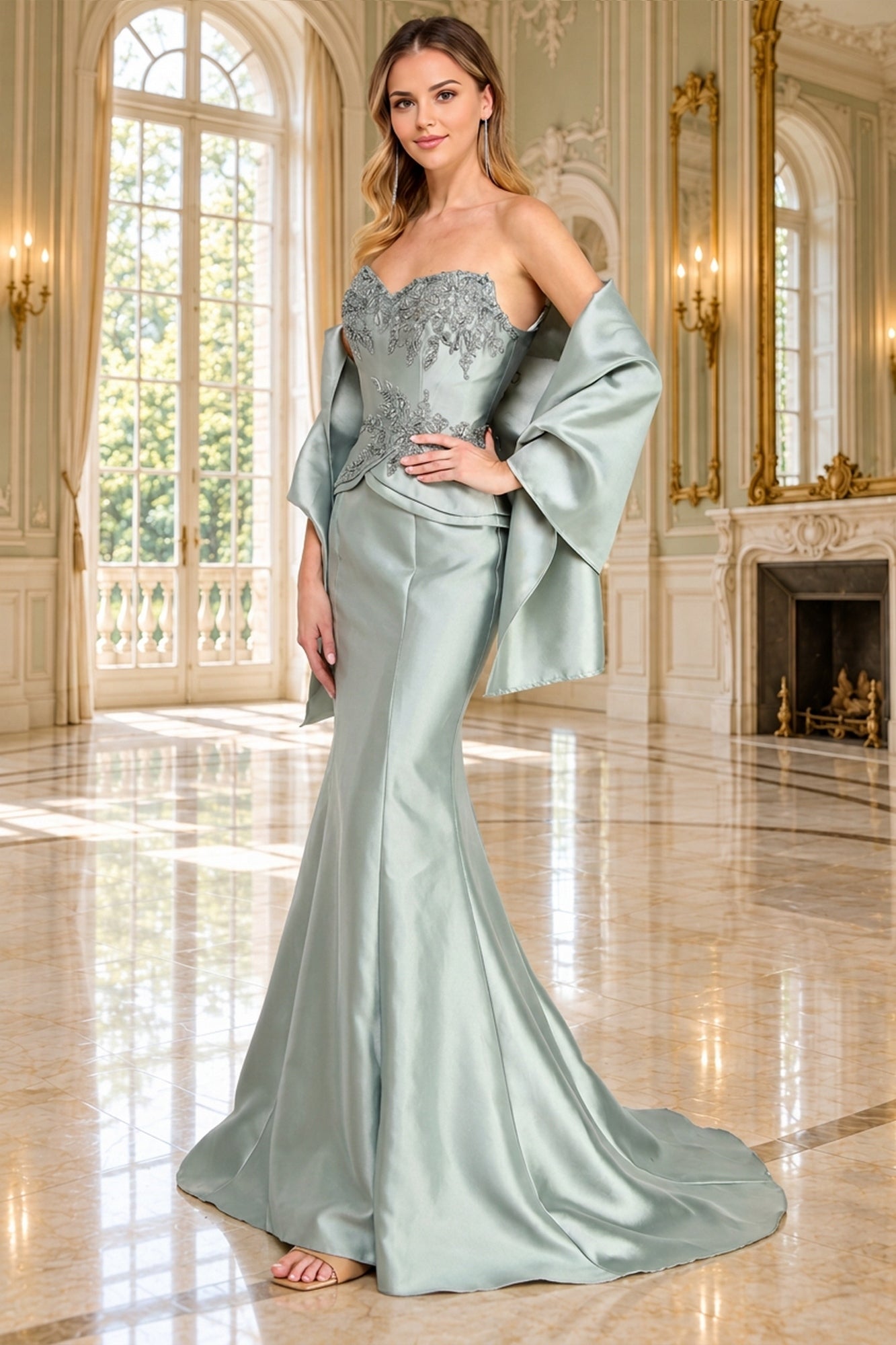 A woman wears the Long Formal Dress: Amelia Couture 2162, a light green, strapless evening gown with an embroidered bodice, floor-length skirt, and a matching shawl draped over her arms.